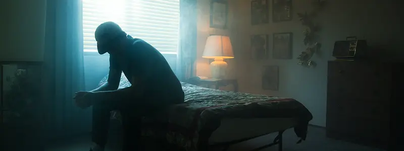 Ung mand på en seng i mørke Opioidmisbrug